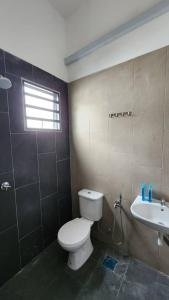 La salle de bains est pourvue de toilettes et d'un lavabo. dans l'établissement Masturi Homestay, à Chemor
