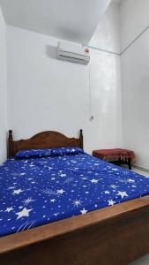 a bed with a blue comforter with stars on it at Masturi Homestay in Chemor