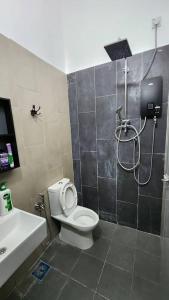 a bathroom with a shower and a toilet and a sink at Masturi Homestay in Chemor