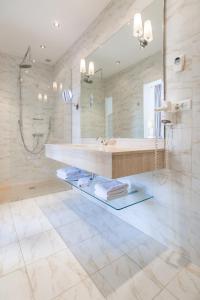 a bathroom with a sink and a shower and a mirror at Villa Léopoldine in Grenade-sur-Garonne