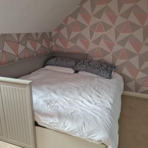 a bedroom with a bed with a geometric wall at Large Double Room with Ensuite and double shower - Homestay in Bishops Frome