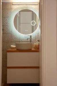 a bathroom with a sink and a mirror at Raise Varkiza Serenity Suite in Vari