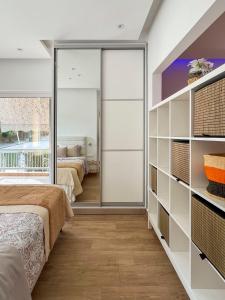 a bedroom with two beds and sliding glass doors at Raise Varkiza Serenity Suite in Vari