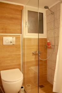 a bathroom with a toilet and a glass shower at Raise Varkiza Serenity Suite in Vari +15 photos