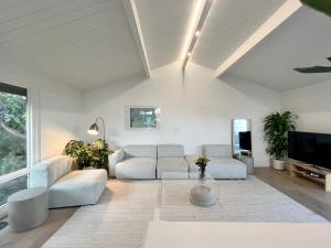 sala de estar con muebles blancos y ventana grande en New Listing -Luxury House on the Riviera , Modern Design, and Panoramic Ocean -30 day Minimum en Santa Bárbara