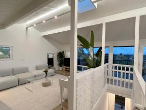 a living room with a white couch and windows at New Listing -Luxury House on the Riviera , Modern Design, and Panoramic Ocean -30 day Minimum in Santa Barbara