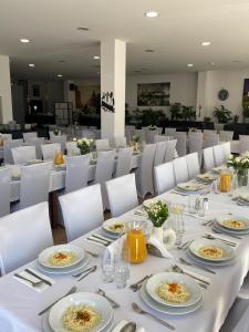 jadalnia z białymi stołami i białymi krzesłami w obiekcie Aparthotel Lumen w Krakowie