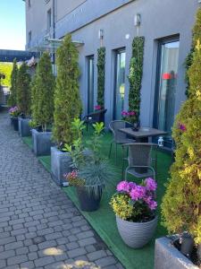 a patio with potted plants and a table and chairs at Aparthotel Lumen in Kraków