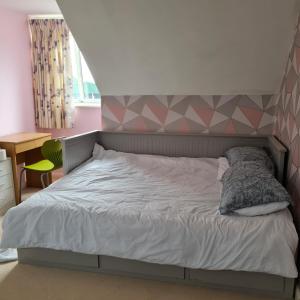 a bedroom with a bed with a geometric headboard at Large Double Room with Ensuite and double shower - Homestay in Bishops Frome