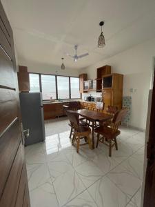 uma cozinha com uma mesa e cadeiras numa cozinha em Big & confortable apartment for 6 - Center of Osu La Crescent em Accra