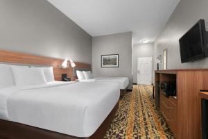 a hotel room with two beds and a flat screen tv at La Quinta by Wyndham Belton - Temple South in Belton