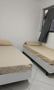 - deux lits assis l'un à côté de l'autre dans une pièce dans l'établissement POUSADA PÉ NA AREIA, à Rio de Janeiro