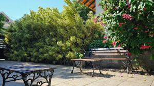 a bench and a picnic table in front of a bush at Beach Guest House - GMT in Rio de Janeiro