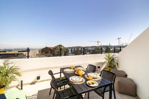 a table and chairs on a balcony with a view at WHome Brand New Lisbon Rooftop with River View in Lisbon