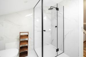 a glass shower in a bathroom with a toilet at WHome Brand New Lisbon Rooftop with River View in Lisbon +18 photos