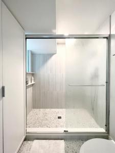 a shower with a glass door in a bathroom at New Listing -Luxury House on the Riviera , Modern Design, and Panoramic Ocean -30 day Minimum in Santa Barbara