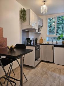 eine Küche mit weißen Schränken und einem Tisch in der Unterkunft appartement calme à 10mn à pied de la villette in Le Pré-Saint-Gervais