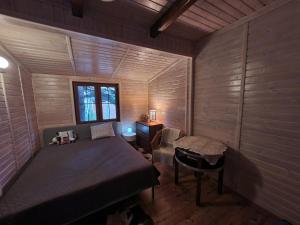 a small bedroom with a bed and a window at Dom Nad Jeziorem in Szteklin
