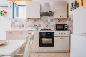 a kitchen with white cabinets and a stove at Camera Demetra in Syracuse +8 photos