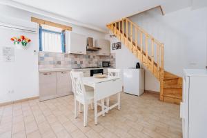 a kitchen with a table and chairs and a staircase at Camera Demetra in Syracuse