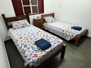 duas camas sentadas uma ao lado da outra num quarto em Casa da Vó Loy e seu espaço verde em Araraquara
