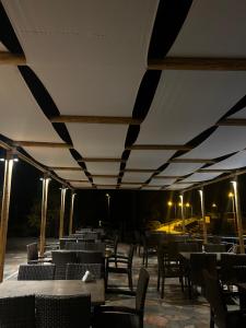 a dining area with tables and chairs at night at Faraggi Hotel in Simvolí