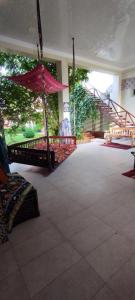 Habitación grande con escalera y sombrilla roja. en Green House ECO HOTEL, en Samarkand