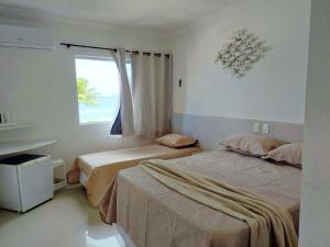 Una habitación de hotel con dos camas y una ventana. en Marinas Tamandaré Beira Mar | Praia dos Carneiros, en Praia dos Carneiros