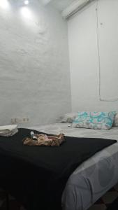 Un dormitorio con una cama con una toalla. en La posada del Kintsugi, en Pilas