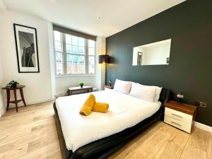 a bedroom with a large bed with two yellow pillows on it at The Kings Palace Central London by Wild in London