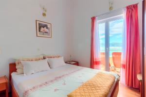 een slaapkamer met een bed en een raam met roze gordijnen bij VILLA JELA in Trogir