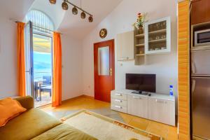 een woonkamer met een bank en een tv en een keuken bij VILLA JELA in Trogir