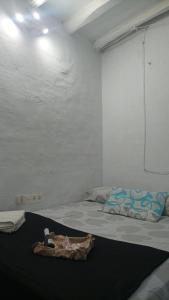 Una habitación blanca con una cama con una bolsa. en La posada del Kintsugi, en Pilas