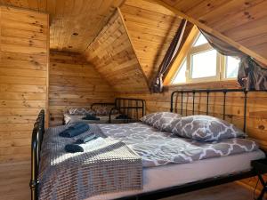 1 Schlafzimmer mit 2 Betten in einer Holzhütte in der Unterkunft Na Jeziornej Domki Wypoczynkowe in Żarnowska
