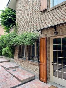 a brick building with a wooden door on it at Casa Matilde in Ferrara