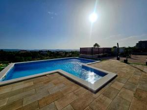 una piscina en la parte superior de un patio en Villa Scolopax rusticola Skradin with heated pool en Skradin