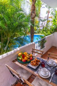 マルベーリャにあるAB Properties - Design Penthouse Marbella - 3mn to Puerto Banús and Beach- Golden Mile- Pool and Tropical Garden Viewのバルコニーにテーブルと食料品のトレイ