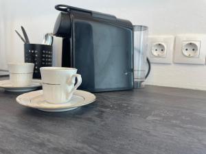 two coffee cups on a counter next to a microwave at Mavrokastro in Adamas