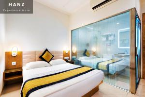 une chambre d'hôtel avec un lit et un mur en verre dans l'établissement HANZ Son Mi Hotel, à Hô-Chi-Minh-Ville