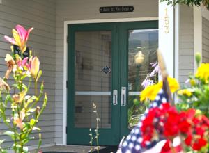 een groene voordeur van een huis met bloemen bij The Lodge at Jackson Village in Jackson