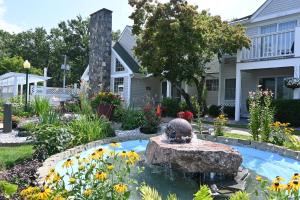 a garden with a fountain in front of a house at The Lodge at Jackson Village in Jackson