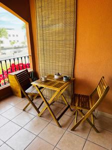 une table et deux chaises assises à côté d'une fenêtre dans l'établissement La Gavina Loft Xàbia & ARCADE, à Jávea