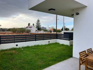 a patio with a fence and a grass field at Elegant Villa with Pool in Gournes