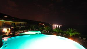 a view of a swimming pool at night at Villaggio Hotel Lido San Giuseppe in Briatico
