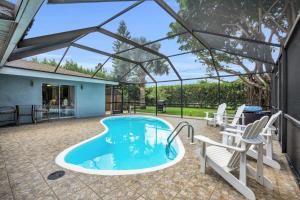 a swimming pool with a tent and chairs at Salt Water Heated Pool Home with a Tiki Bar, a Garage Game Room and 4 Bikes in Naples