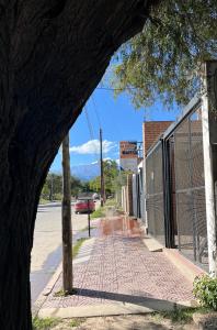 una calle vacía con un edificio y un árbol en Departamentos "La Perla" en Andalgalá