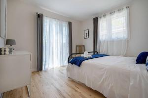 um quarto com uma cama e uma grande janela em La Riviera - Cottage in the City em Gatineau