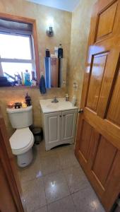 a bathroom with a toilet and a sink at comfortable room with balcony near the train in Woodside