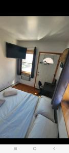 a bedroom with a bed and a desk and a window at comfortable room with balcony near the train in Woodside