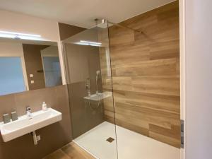 a bathroom with a sink and a glass shower at Hofgut Breitenbach in Markdorf